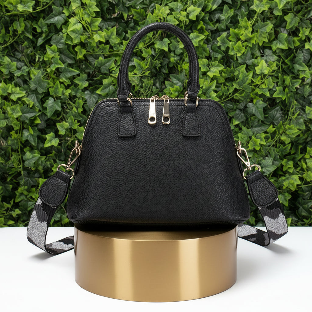 Black handbag with gold accents on a white background